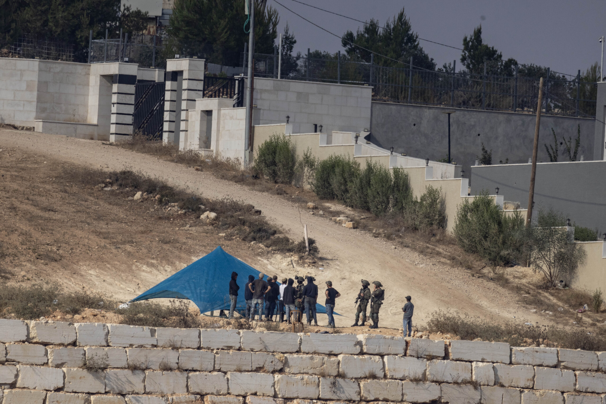 מתנחלים וחיילים לצד אוהל שהקימו מתנחלים, מחוץ לבתים הנצורים בקוסרא, 14 באוגוסט, 2026 (צילום: אורן זיו)