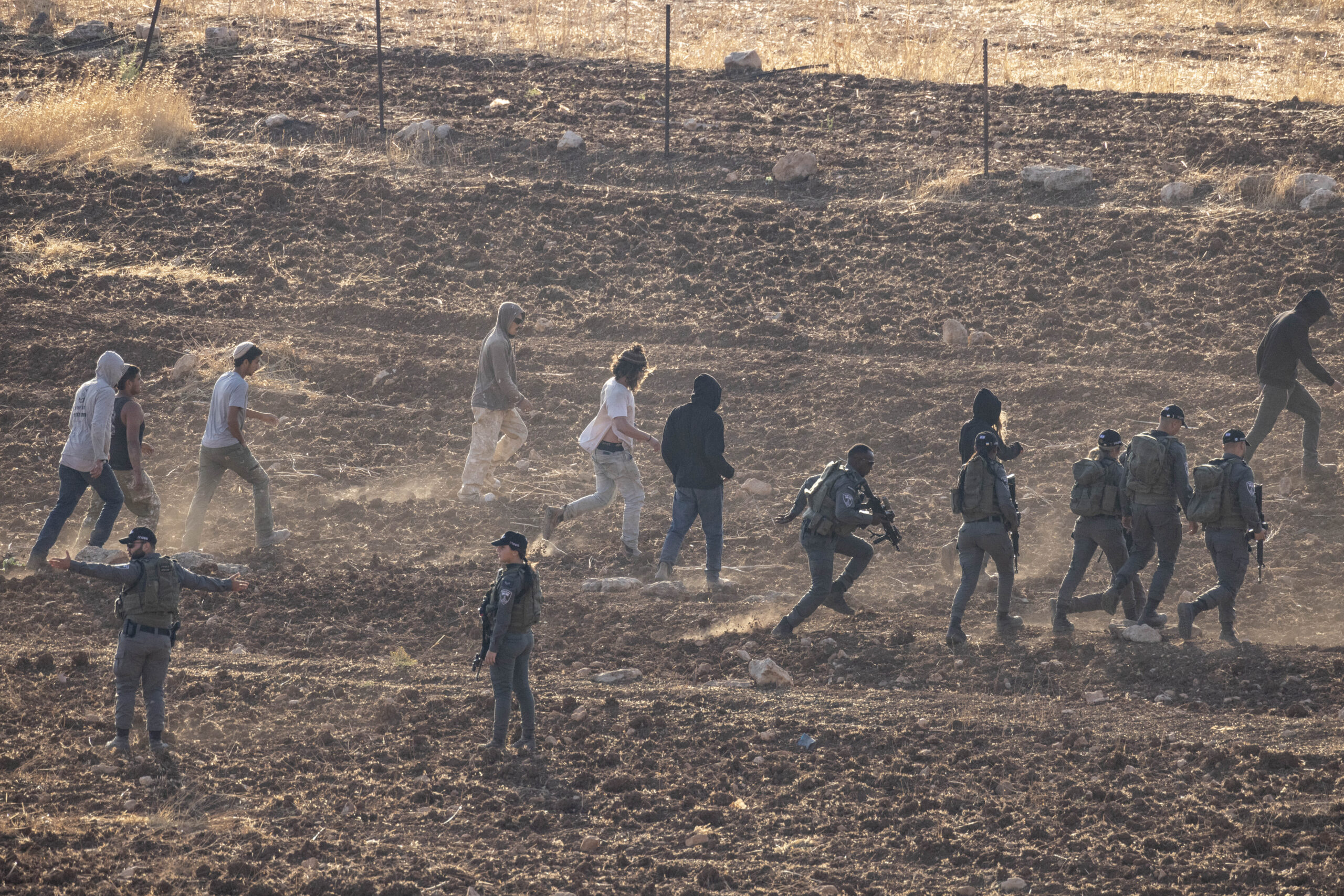 מתנחלים, חיילים ושוטרי מג"ב בשדה בו היה אמור להתקיים חריש באדמות הכפר אל-מוע'ייר, ב-11 באוגוסט 2026 (צילום: אורן זיו)