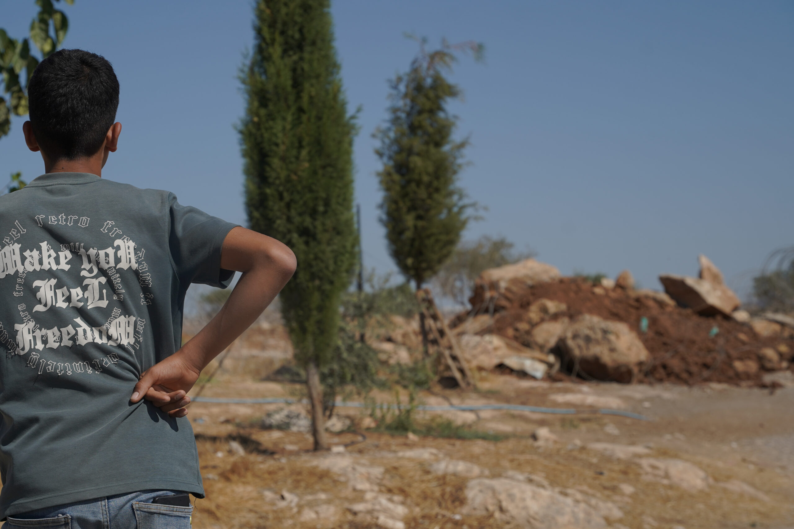 החיילים לא נתנו הסבר. ילד ממשפחת ג'בארין באל-מניה משקיף על תלולית העפר שחוסמת את הכניסה לביתו (צילום: תמנה רוז פרץ)
